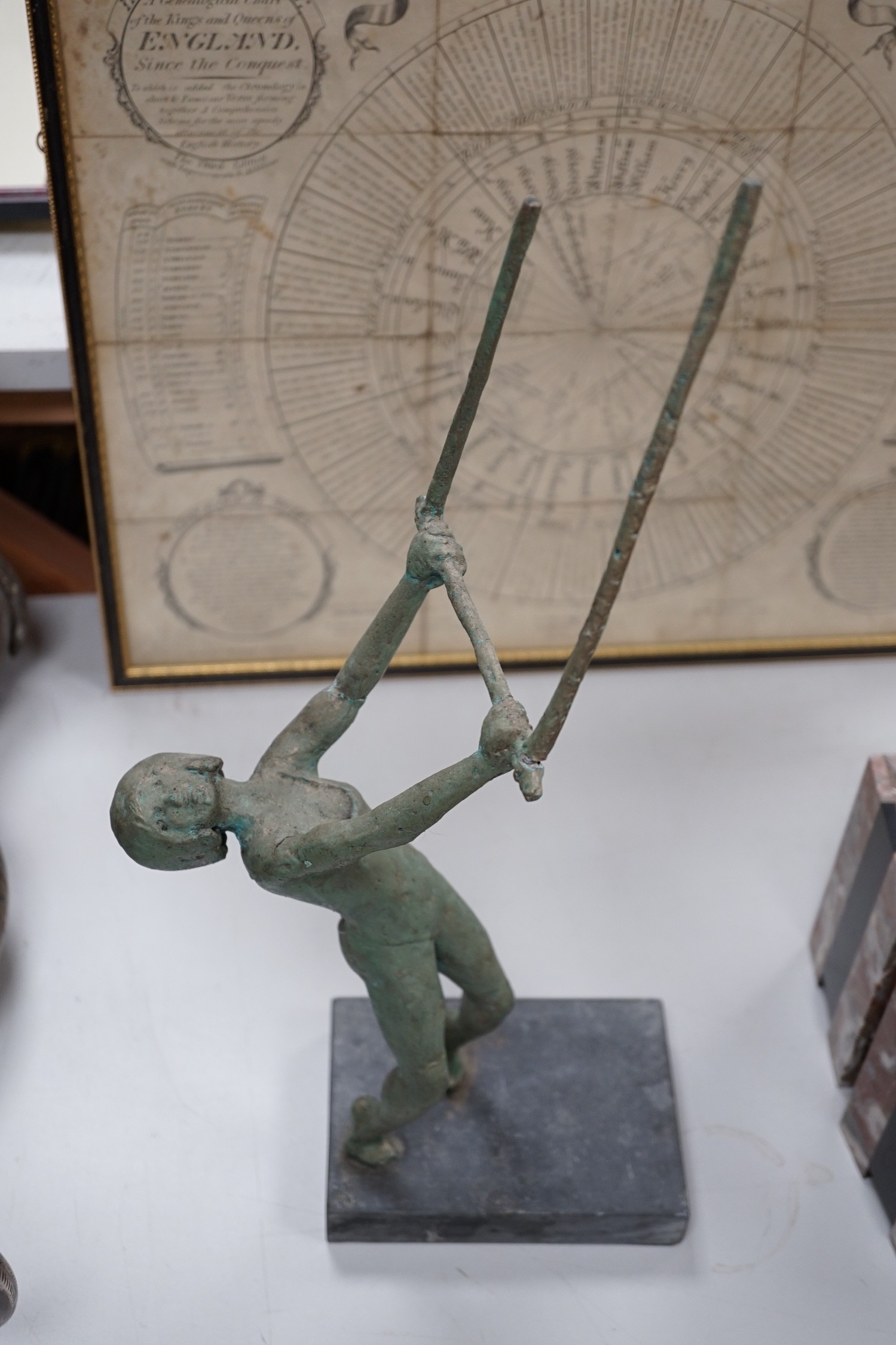 A maquette sculpture of a gymnast in pose swinging on a bar, 48cm tall